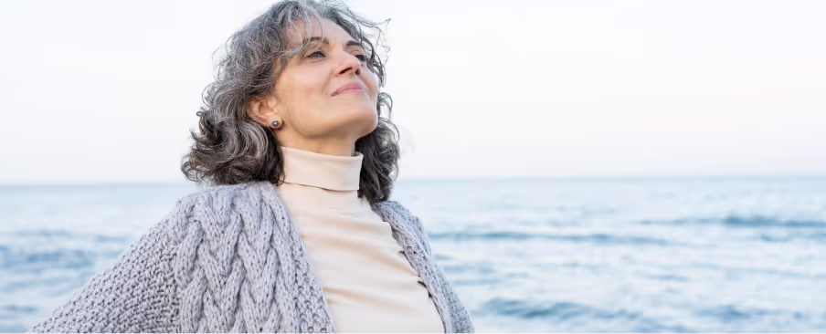 A woman is her 50s, enjoying the sea