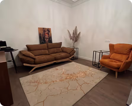 This is a photo of alina's office, where you can see a couch and some decorations on the wall.

