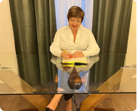 photo of alina in her office standing at a desk
